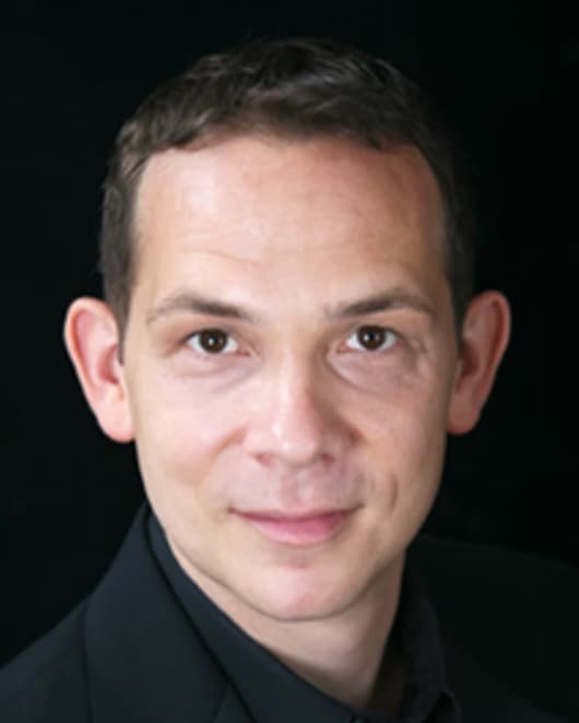 David Simmons, photographed against a dark ground.