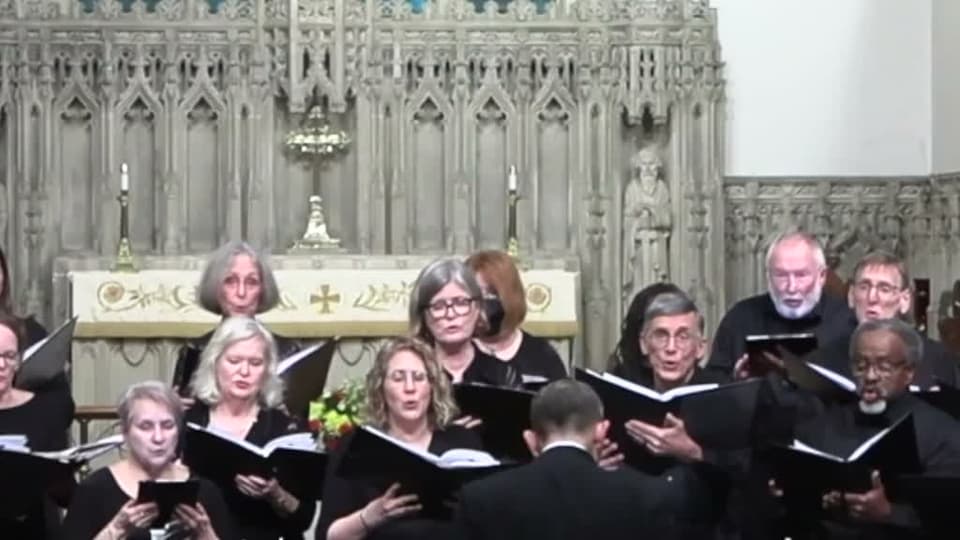 CoroAllegro singing, photographed mid-phrase from the front of the church.